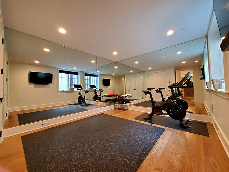 Full-wall gym mirror installation in a home fitness studio